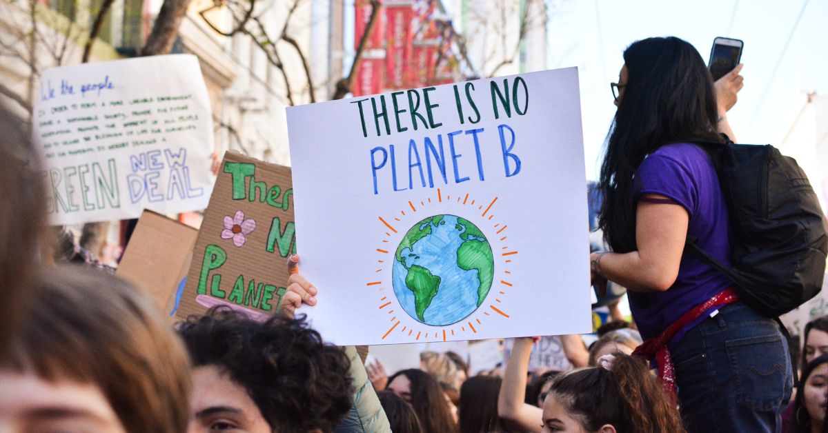 Picture of envrionmental activists, holding a sign that says "there is no planet B".